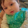 baby, child, infant, face, hands, clothing, green_outfit, polka_dots, cute, portrait, indoors, closeup, young_child, skin, person, head, eyes, expression, sitting, soft_light