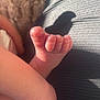 baby, foot, skin, closeup, sunlight, shadow, texture, blanket, soft, infant, toes, leg, human, newborn, warm, natural_light, relaxation, comfort, home, casual