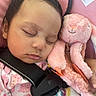 baby, sleeping, infant, car_seat, seat_belt, stuffed_animal, pink_bunny, plush_toy, blanket, pastel, portrait, close_up, peaceful, indoors, travel, safety_label, clothing, floral_pattern, cozy, child