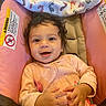 Adrianna is registered to the contest to win money with this photo: baby, infant, child, smiling, happy, portrait, sitting, pink_clothing, blanket, car_seat, cushion, indoor, face, eyes, hair, pacifier, hands, baby_seat, cozy, photography