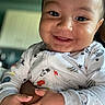 Kendrick is registered to the contest to win money with this photo: apparel, baby, child, closeup, cute, expression, face, hands, happy, holding, indoor, infant, light, onesie, person, portrait, skin, smile, space_theme, young