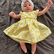 Stella is registered to the contest to win money with this photo: baby, bonnet, cap, clothing, couch, dress, eveningdress, face, footwear, formalwear, furniture, hat, head, newborn, person, photography, portrait, sandal, shoe, toy