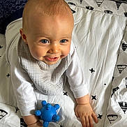 Tom a rejoint le concours — aidez-le/la à gagner de superbes lots ! baby, bed, bedroom, blanket, bodypart, crawling, face, finger, furniture, hand, happy, head, helmet, person, photography, portrait, quilt, sitting, smile, toy