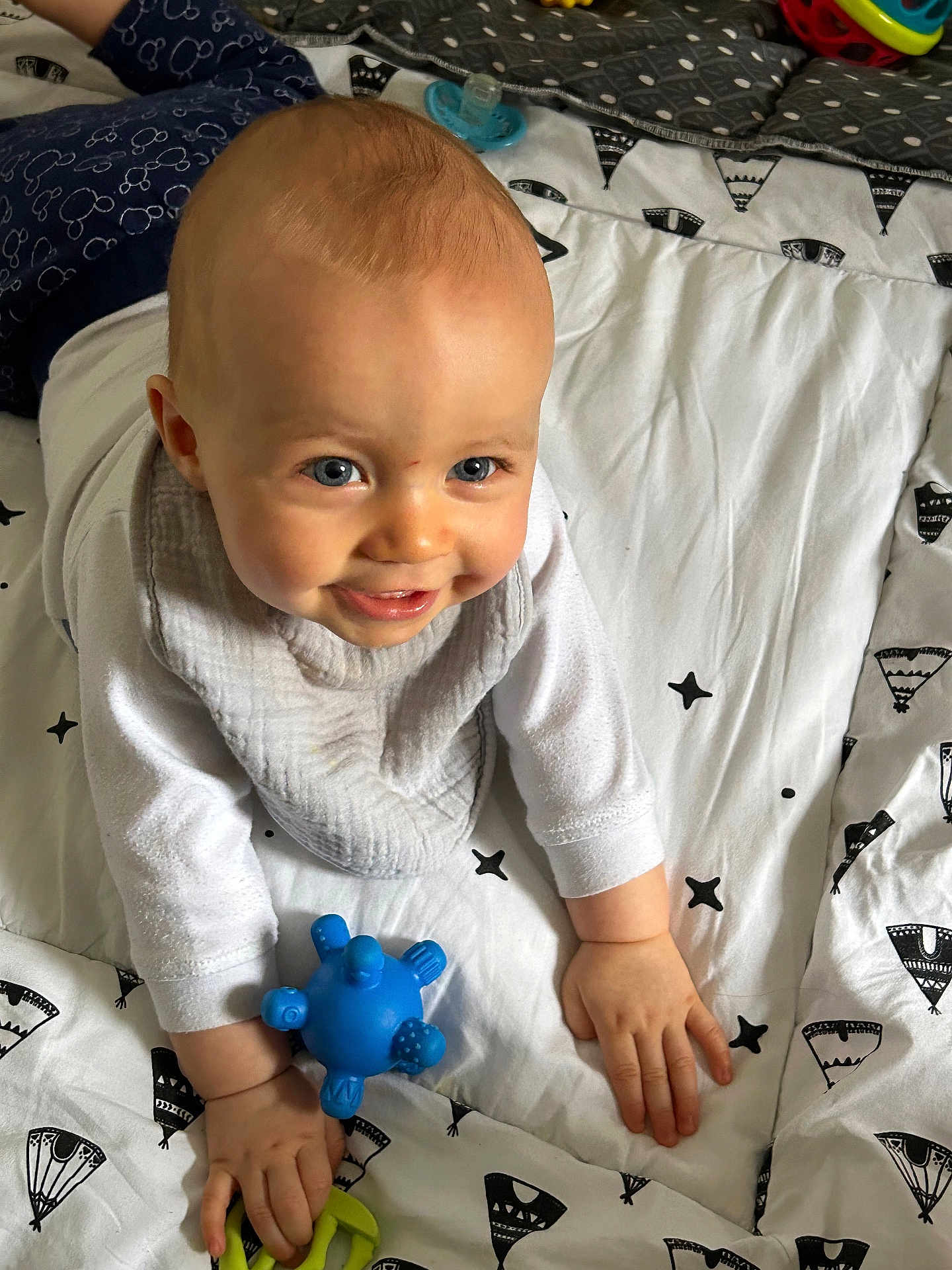 Tom a rejoint le concours — aidez-le/la à gagner de superbes lots ! baby, bed, bedroom, blanket, bodypart, crawling, face, finger, furniture, hand, happy, head, helmet, person, photography, portrait, quilt, sitting, smile, toy