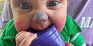 Kesston joined the competition — help win amazing prizes! baby, blue_eyes, casual, chewing, child, close_up, colorful, curious, expression, face_paint, green_shirt, hand, holding, infant, outdoor, person, playful, portrait, purple_cup, skin