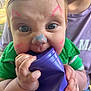 Kesston joined the competition — help win amazing prizes! baby, face_paint, blue_eyes, green_shirt, purple_cup, chewing, close_up, child, person, hand, curious, outdoor, casual, playful, skin, infant, portrait, expression, holding, colorful