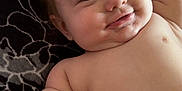 Kesston is registered to the contest to win money with this photo: baby, child, face, skin, arm, knee, freckles, blanket, pattern, smile, lying_down, playful, indoor, human, portrait, closeup, happy, cute, infant, person