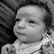 Dylan is registered to the contest to win money with this photo: baby, infant, face, black_and_white, striped_clothing, cute, lion_patch, hand, curly_hair, portrait, resting, expression, newborn, child, soft_texture, blanket, indoors, young, closeup, skin