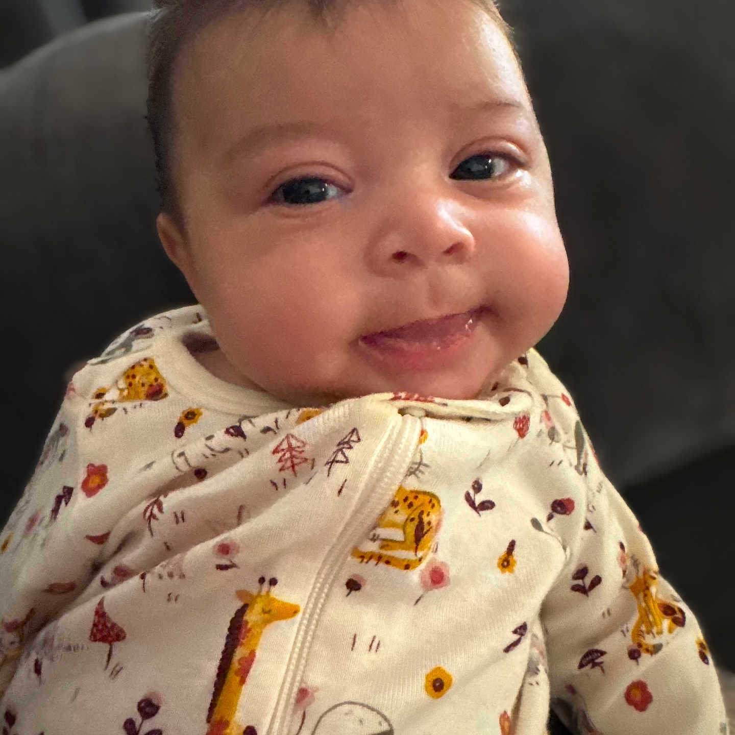 Bobbielee is registered to the contest to win money with this photo: animal_print, baby, cheeks, child, clothing, cozy, cute, cute_expression, face, giraffe, indoor, infant, onesie, panda, person, portrait, smile, soft_background, tongue, young