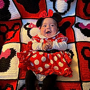 Adaline is registered to the contest to win money with this photo: baby, infant, child, minnie_mouse, costume, red_dress, polka_dots, bow, headband, smiling, happy, sitting, portrait, crocheted_blanket, colorful, red, black, white, indoor, close_up