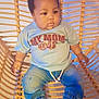 baby, child, infant, blue_shirt, denim_pants, pink_shoes, woven_chair, indoor, balloons, cute, adorable, sitting, casual_clothing, portrait, young_child, expression, fashion, comfort, home, person