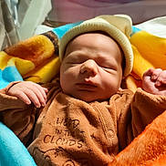 Soulayman participe au concours pour gagner de l'argent avec cette photo : newborn, baby, sleeping, hat, blanket, hospital, bassinet, pajamas, cozy, infant, child, cute, resting, soft, warm, indoors, portrait, peaceful, small, wrapped