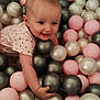 baby, child, smiling, playing, ball_pit, plastic_balls, pink, gray, white, indoor, cute, happy, person, head, face, arm, toddler, clothing, toy, fun