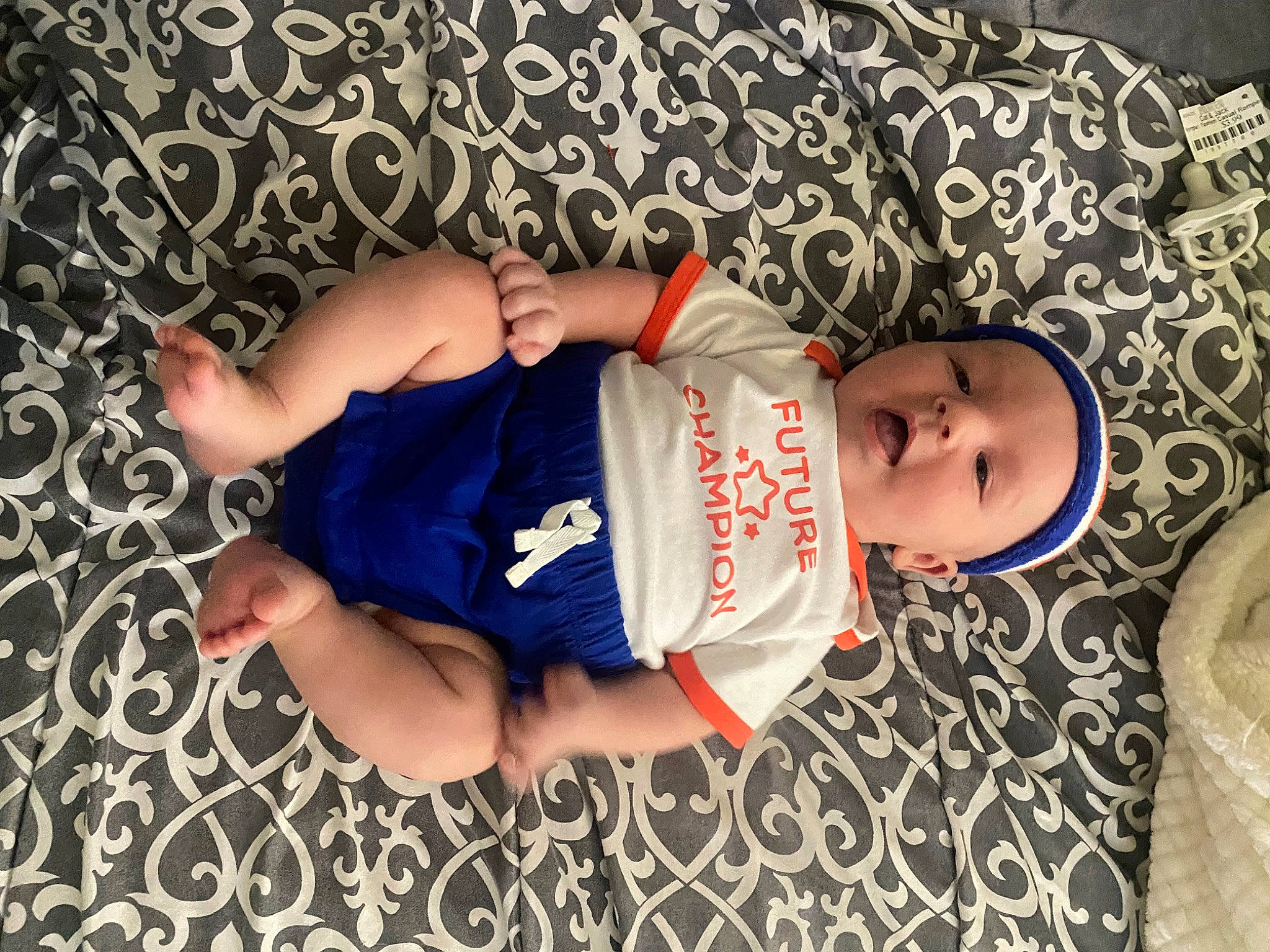 Blake is registered to the contest to win money with this photo: arm, baby_toddler_clothing, comfort, elbow, finger, glasses, hand, hat, headgear, human_body, human_leg, leg, nail, pattern, person, sleeve, t_shirt, thigh, toddler, trunk