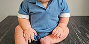 Cooper is registered to the contest to win money with this photo: baby, child, smiling, blue_clothing, sitting, floor, wooden_floor, cheerful, cute, portrait, indoors, skin, face, head, hands, feet, infant, happy, young, person