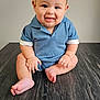 baby, child, smiling, blue_clothing, sitting, floor, wooden_floor, cheerful, cute, portrait, indoors, skin, face, head, hands, feet, infant, happy, young, person