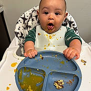 Cooper joined the competition — help win amazing prizes! baby, messy, food, highchair, plate, bib, hands, face, expression, meal, feeding, child, indoor, clothing, star_pattern, table, utensils, cute, person, kitchen