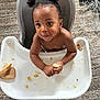 toddler, child, high_chair, bread, crumbs, carpet, food, snack, messy, indoor, person, cute, hair_buns, looking_up, hands, tray, feeding_time, baby, skin, expression
