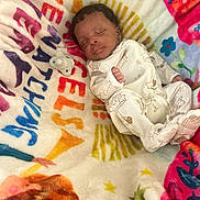 Omega Dadds joined the competition — help win amazing prizes! baby, sleeping, infant, blanket, onesie, pacifier, soft_texture, colorful, animal_print, peaceful, cute, child, indoors, resting, cozy, newborn, patterned_blanket, portrait, comfort, sleep