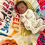 baby, sleeping, infant, blanket, onesie, pacifier, soft_texture, colorful, animal_print, peaceful, cute, child, indoors, resting, cozy, newborn, patterned_blanket, portrait, comfort, sleep