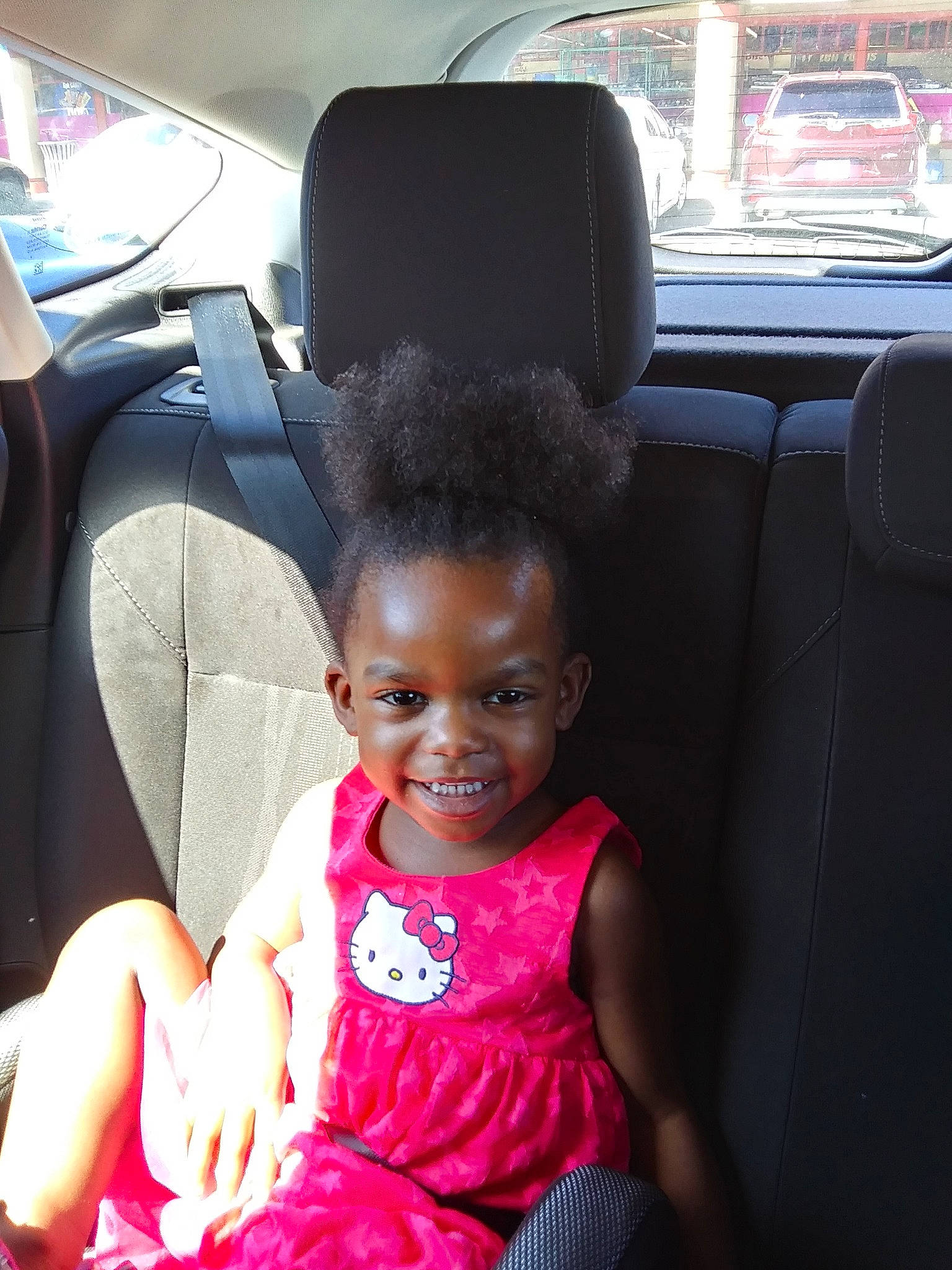 Yalanda is registered to the contest to win money with this photo: auto_part, baby, black_hair, car, car_seat, child, electronic_device, family_car, joy, passenger, people, person, pink, plant, sitting, skin, smile, technology, toddler, vacation