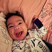 Jayonni joined the competition — help win amazing prizes! baby, infant, smiling, laughing, onesie, pajamas, bed, pillow, blanket, floral, cute, face, eyes, mouth, hand, indoor, cozy, portrait, happy, nursery
