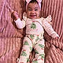 Jayonni is registered to the contest to win money with this photo: baby, infant, child, smiling, headband, bow, pink_blanket, onesie, pajamas, christmas_tree_pattern, cozy, plush_texture, portrait, lying_down, toes, hands, cheeks, happy, clothing, indoor