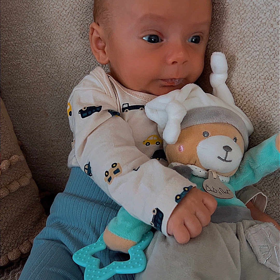 Lyo a rejoint le concours — aidez-le/la à gagner de superbes lots ! baby, infant, plush_toy, teether, blue_pants, long_sleeve_shirt, car_pattern, couch, textured_fabric, seated, child, cute, indoors, soft_toy, star_teether, comfort, expression, small_hand, head, face