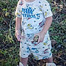 Ryder is registered to the contest to win money with this photo: casual, child, clothing, curly_hair, daylight, footwear, grass, greenery, holding, nature, outdoor, paw_patrol, person, playful, shirt, shorts, sneakers, standing, toddler, young_child