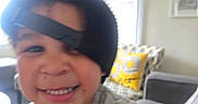 Ryder is registered to the contest to win money with this photo: blurred, cap, casual, child, couch, cute, face, fun, happy, hat, home, indoor, living_room, person, pillow, shirt, smiling, toddler, window, young