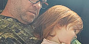 Piper is registered to the contest to win money with this photo: camouflage_shirt, casual_clothing, chair, child, closeup, comfort, family, glasses, hair, indoor, man, nap, natural_light, pacifier, peaceful, portrait, relaxation, rest, sleeping, toddler