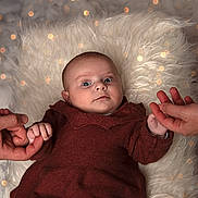 Maddie participe au concours pour gagner de l'argent avec cette photo : baby, infant, hands, knitwear, fluffy_rug, bokeh, close_up, portrait, cute, soft_lighting, skin, human, child, warm_colors, holding_hands, texture, face, expression, cozy, indoor