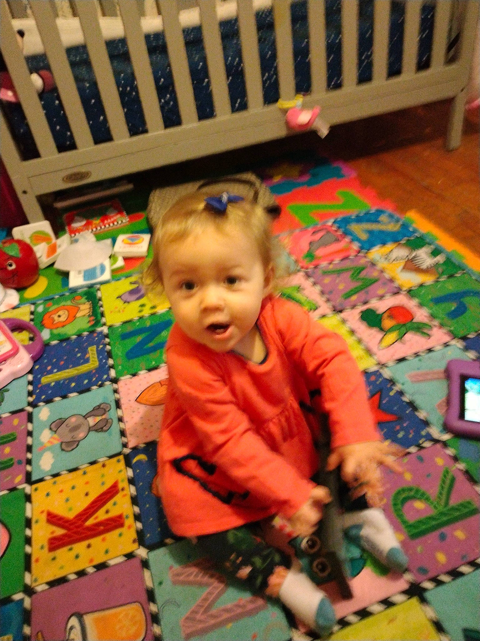 Olivia is registered to the contest to win money with this photo: baby, baby_products, baby_toddler_clothing, baby_toys, carpet, child, floor, flooring, fun, leisure, pattern, person, play, playmat, product, room, sitting, surprise, toddler, toy