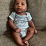 baby, child, infant, sitting, couch, onesie, clothing, face, expression, curious, indoors, brown, texture, furniture, person, portrait, skin, feet, hands, cute