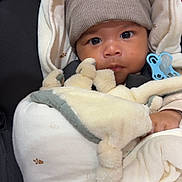 Leeroy participe au concours pour gagner de l'argent avec cette photo : baby, infant, hat, pom_pom, blanket, plush_toy, pacifier, clothing, face, expression, wrapped, cozy, warm, child, cute, newborn, indoors, seated, soft, bundle