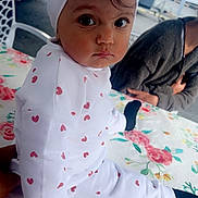 Kaïssy participe au concours pour gagner de l'argent avec cette photo : toddler, child, white_clothing, headband, bow, table, floral_pattern, heart_pattern, indoor, person, face, eyes, expression, sitting, tablecloth, black_socks, cute, young_child, curious, portrait