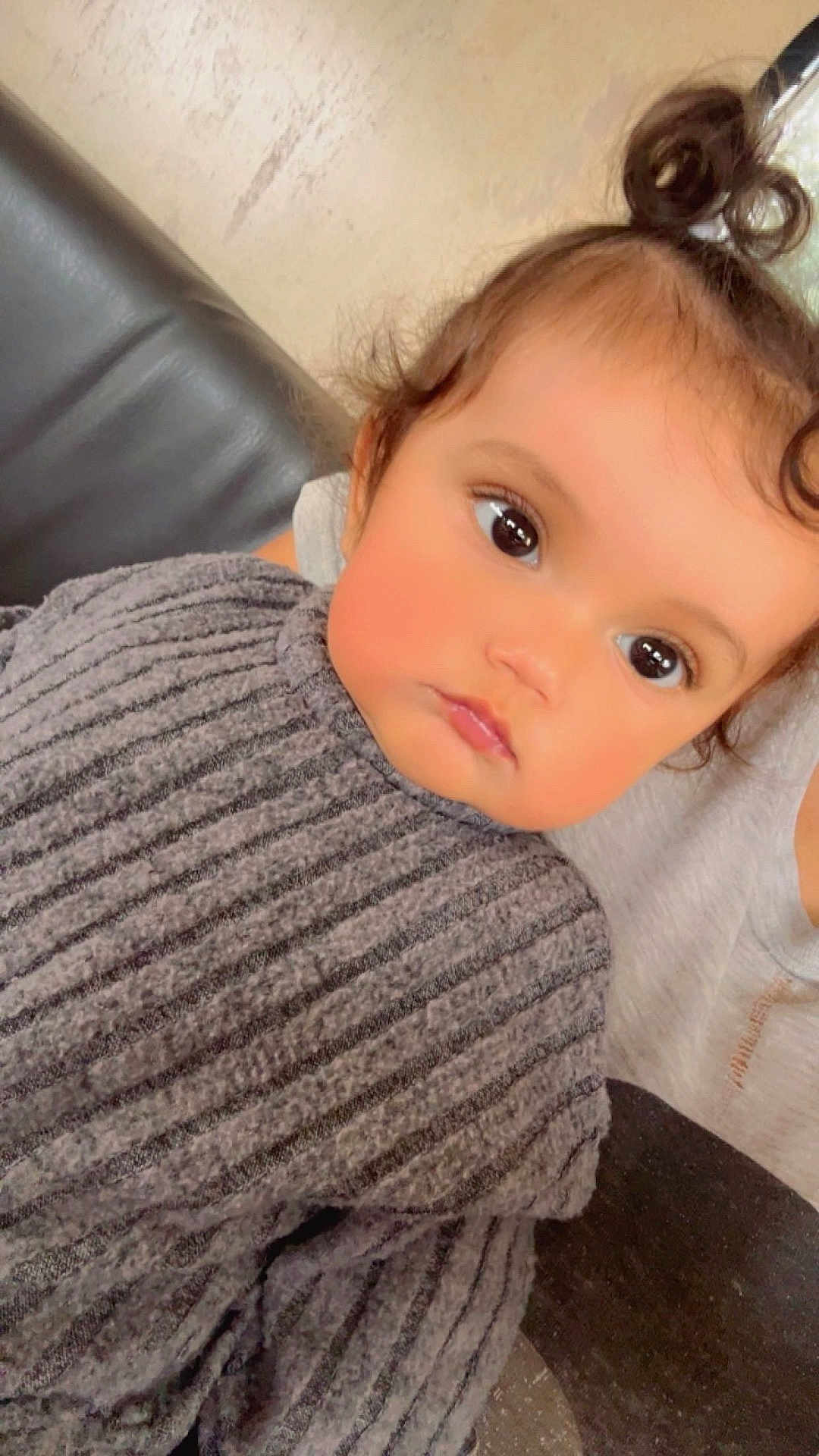 Kaïssy participe au concours pour gagner de l'argent avec cette photo : child, toddler, face, eyes, hair, curly_hair, sweater, gray_sweater, ribbed_sweater, portrait, indoor, couch, leather_couch, person, closeup, cute, expression, topknot, skin, young