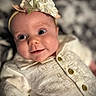baby, child, infant, headband, flower, smile, face, eyes, clothing, button, bunny_pattern, cute, portrait, closeup, soft_lighting, indoors, apparel, headwear, happy, newborn
