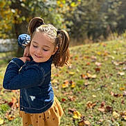 Leah is registered to the contest to win money with this photo: child, girl, pigtails, denim_jacket, yellow_skirt, outdoor, grass, leaves, fall, sunlight, smile, happy, cute, nature, portrait, playful, seasonal, young, person, fashion