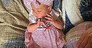 Gracelynn joined the competition — help win amazing prizes! baby, child, couch, cozy, cute, dress, fabric, hand, headband, human, indoor, infant, person, pillow, relaxed, seated, skin, soft_lighting, striped_clothing, textile