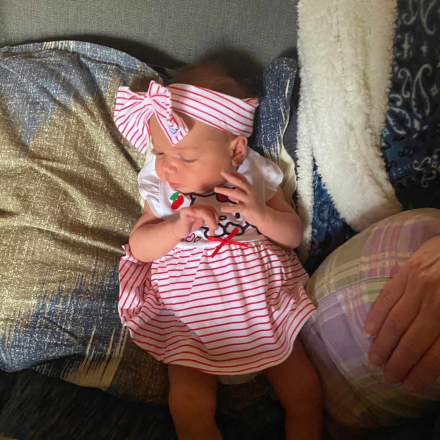 Gracelynn joined the competition — help win amazing prizes! baby, infant, dress, headband, striped_clothing, pillow, couch, hand, indoor, person, child, fabric, textile, cute, seated, soft_lighting, cozy, relaxed, skin, human