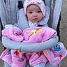 baby, blanket, child, colorful, cozy, cute, expression, face, footwear, hat, infant, outdoor, pajamas, person, pink, safety_strap, seated, stroller, wheels, young