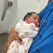 Enrique joined the competition — help win amazing prizes! baby, newborn, infant, person, onesie, owl_print, blue_shirt, hand, arm, indoor, refrigerator, white_wall, flooring, cute, sleepy, cradled, portrait, human_skin, casual_clothing, domestic