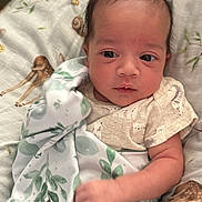 Myles is registered to the contest to win money with this photo: baby, infant, blanket, bed, deer_print, clothing, face, hand, lying_down, person, sleepwear, soft_texture, cute, newborn, resting, patterned_fabric, indoors, comfort, toddler, portrait