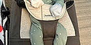 Myles is registered to the contest to win money with this photo: baby, infant, bouncer, babybjorn, green_onesie, mittens, carpet, indoor, child, person, comfortable, soft, baby_gear, small, cute, seated, looking, face, expression, resting