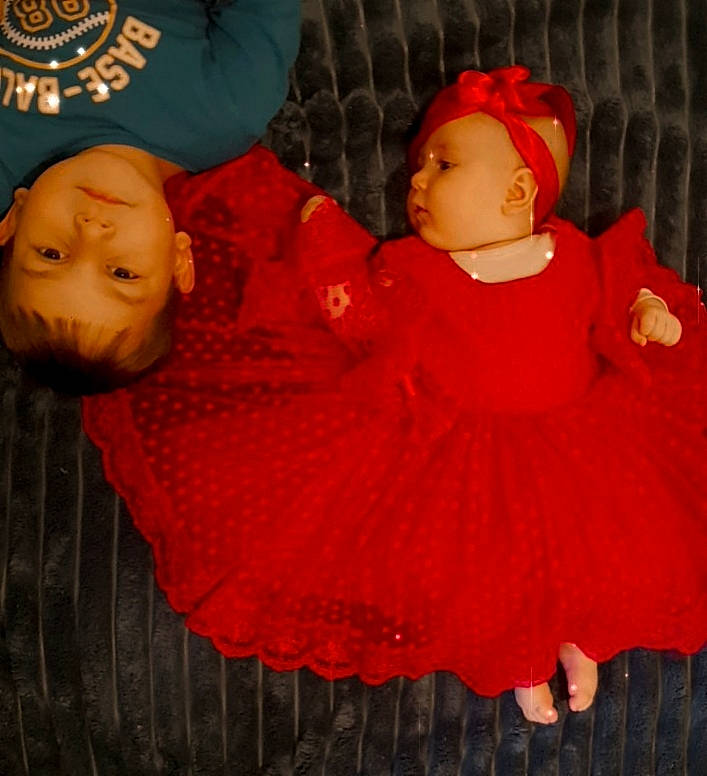 Elif a rejoint le concours — aidez-le/la à gagner de superbes lots ! baby, baby_toddler_clothing, cheek, chin, comfort, dress, eye, face, facial_expression, hat, headgear, human_body, lip, outerwear, person, pink, red, skin, sleeve, textile