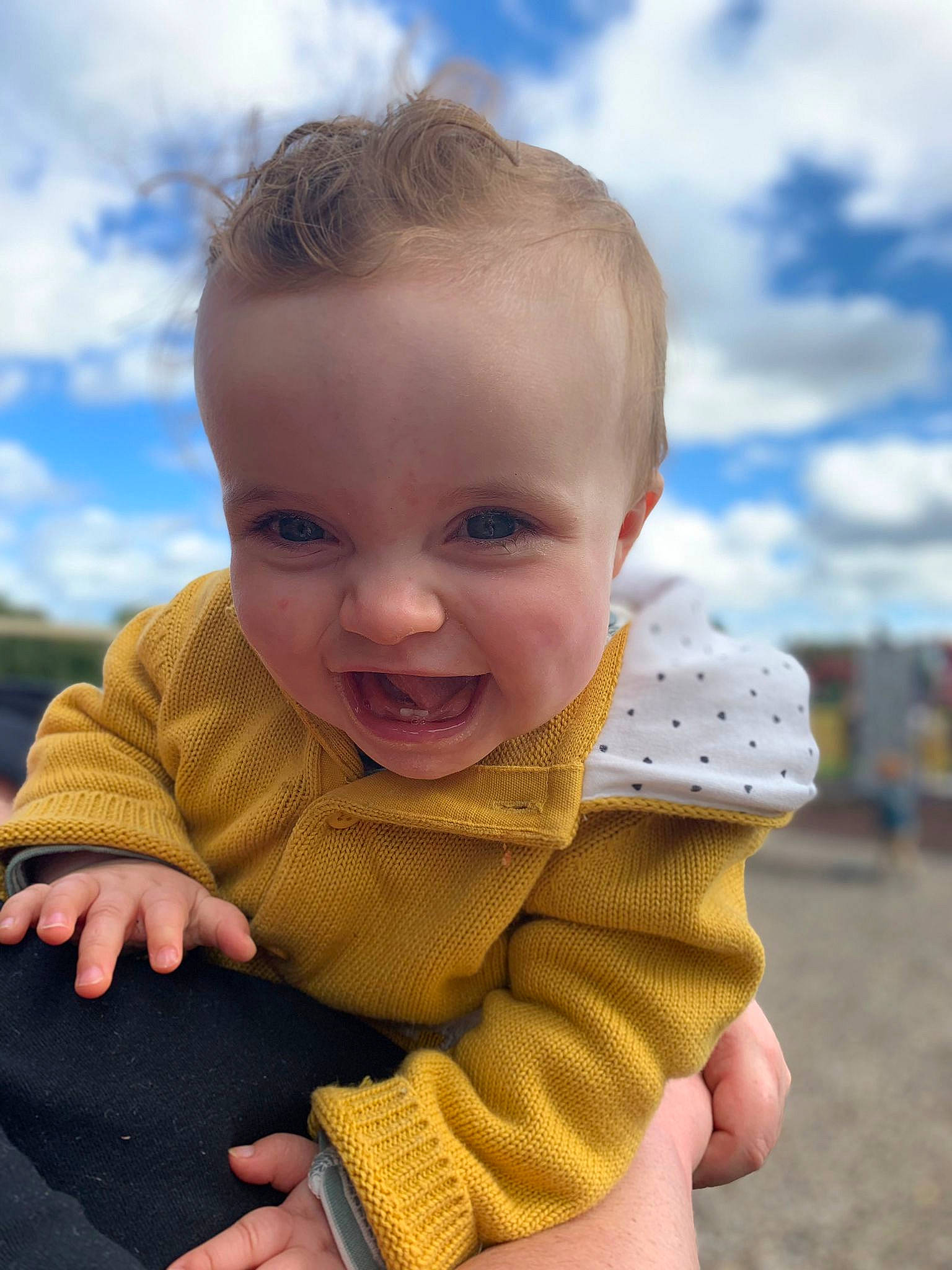 Harriet is registered to the contest to win money with this photo: baby_toddler_clothing, chin, cloud, face, finger, gesture, grass, hair, hand, happy, human_body, lip, nose, people_in_nature, person, skin, sky, sleeve, toddler, tree