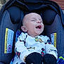 baby, blanket, canopy, car_seat, closeup, cute, fabric_pattern, happy, infant, laughing, mittens, mouth_open, neon_light, onesie, outdoor, portrait, seat_padding, smiling, warning_label, wooden_structure