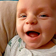 Sebastian joined the competition — help win amazing prizes! baby, smiling, face, infant, clothing, onesie, happy, closeup, portrait, child, skin, head, eyes, mouth, expression, cozy, blanket, background, indoor, cute