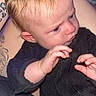 Oakley joined the competition — help win amazing prizes! baby, infant, child, black_clothing, blond_hair, tattoo, hand, face, expression, curious, indoor, person, skin, head, holding, sitting, closeup, protective, adult, portrait